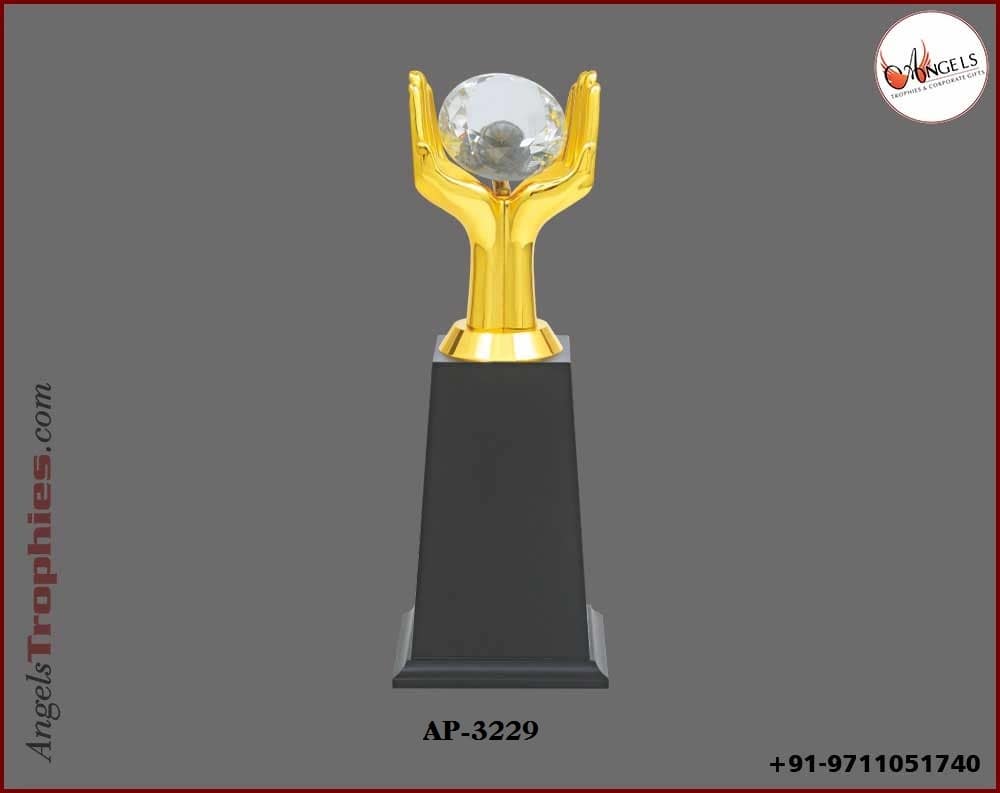Metal golden hand with crystal globe with wooden base