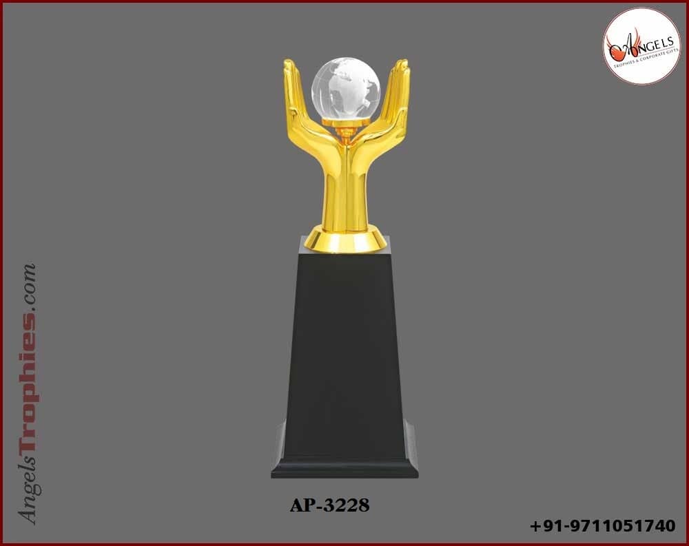 Metal golden hand with crystal globe with wooden base